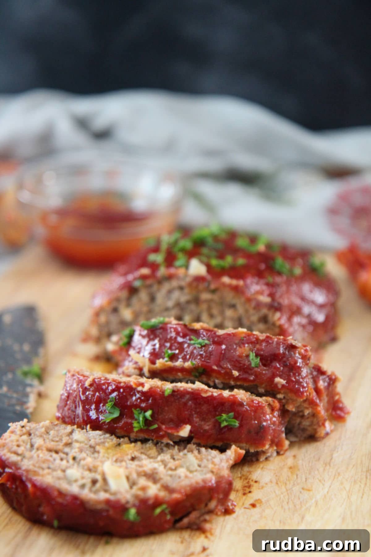slices of turkey meatloaf on a wooden board with ketchup on the side