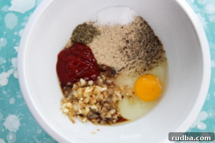 egg, ketchup, onions, seasonings, and breadcrumbs in a white bowl