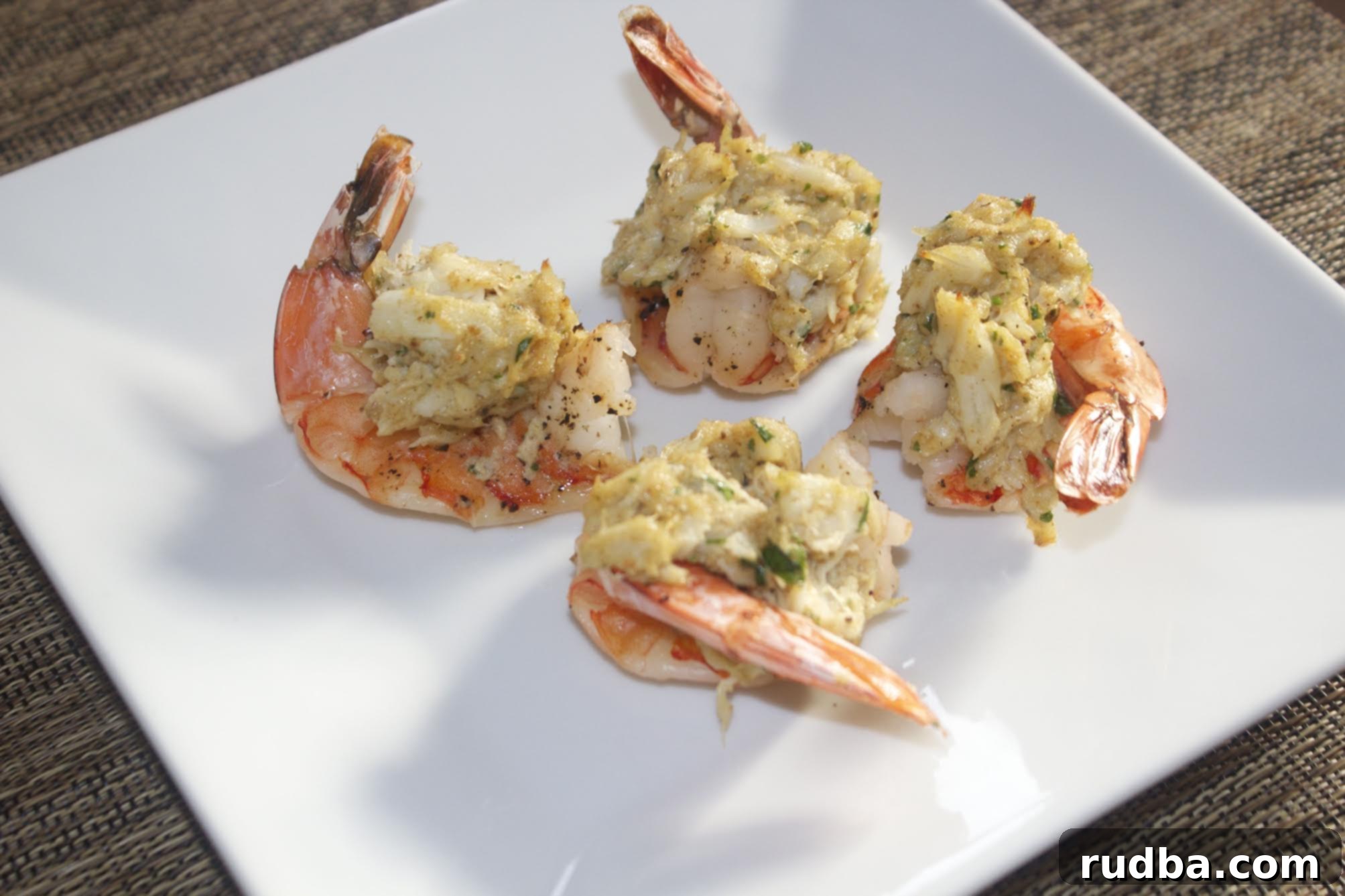 four stuffed shrimp on a white plate 