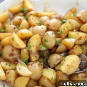 baby yellow potatoes in a white bowl with a aspoon