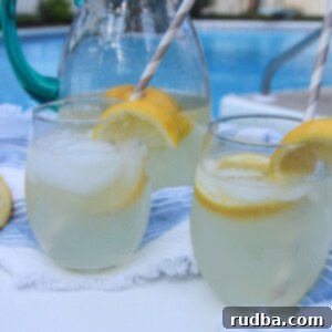 Old-Fashioned Lemonade 5 two glasses of lemonade and a glass pitcher in the background