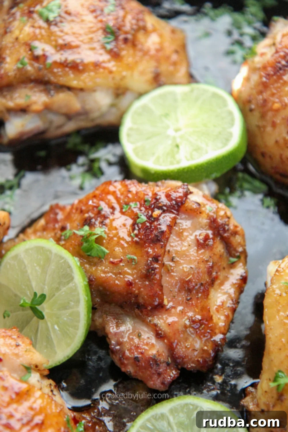 bone in chicken thighs in a cast iron skillet with slices of lime 