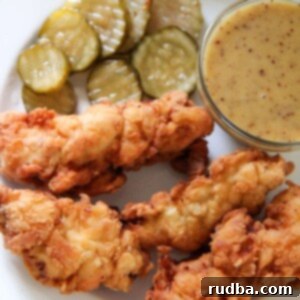 Golden Tenders, Zesty Honey Mustard 6 chicken tenders, honey mustard, and pickles on a white plate