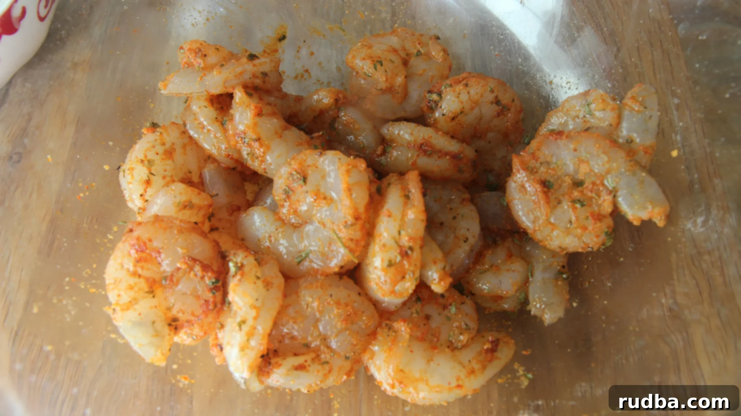 Marinated raw shrimp in a glass bowl. 