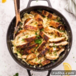 Creamy Cajun Chicken Pasta 5 Cajun chicken, farfalle pasta, parsley, and a wooden spoon in a black skillet.