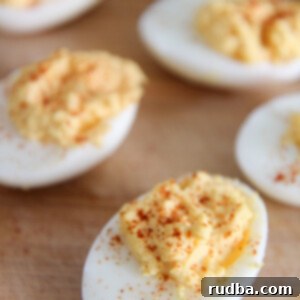 deviled eggs with paprika on a wooden board