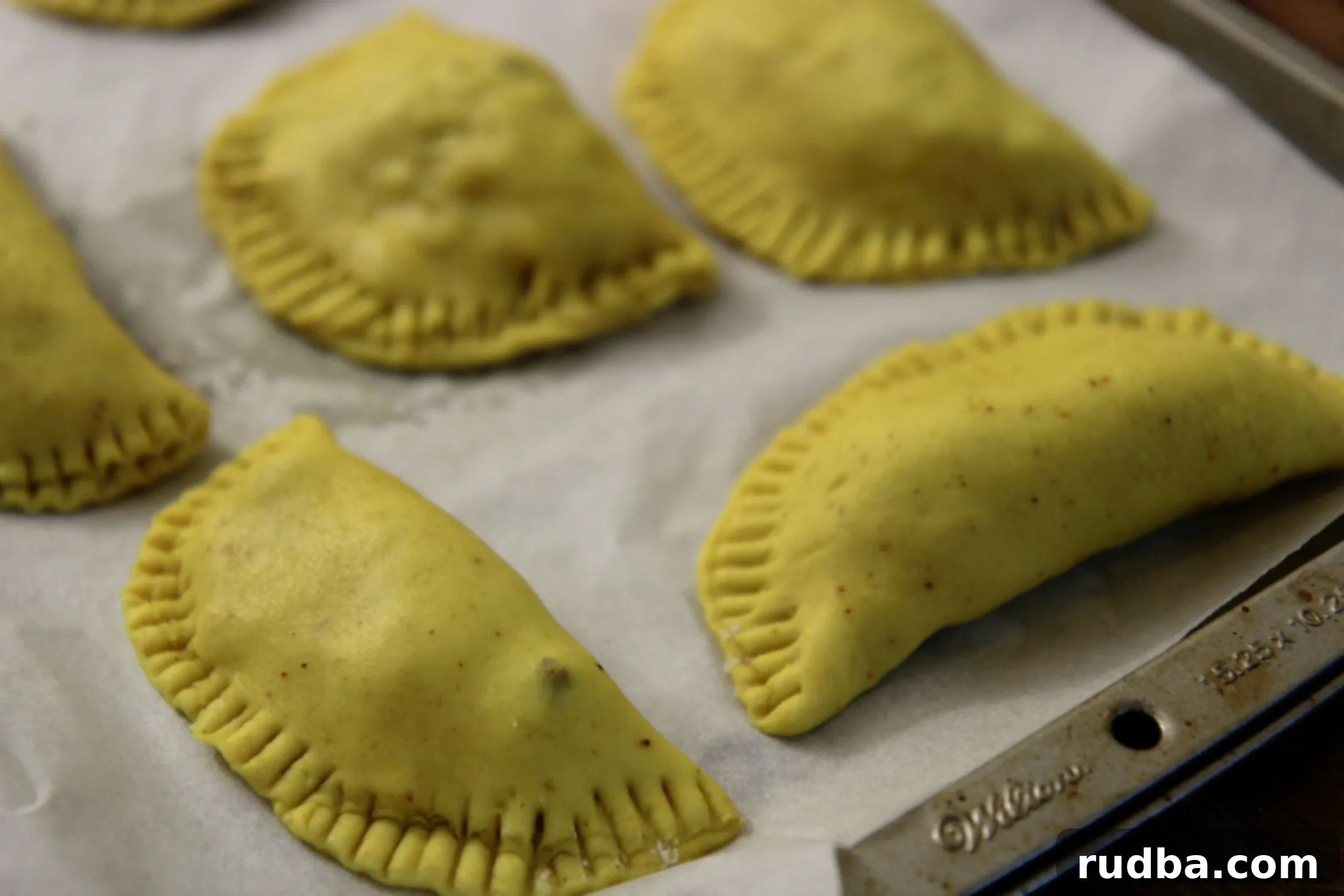 Jamaincan beef patties on a baking sheet. 