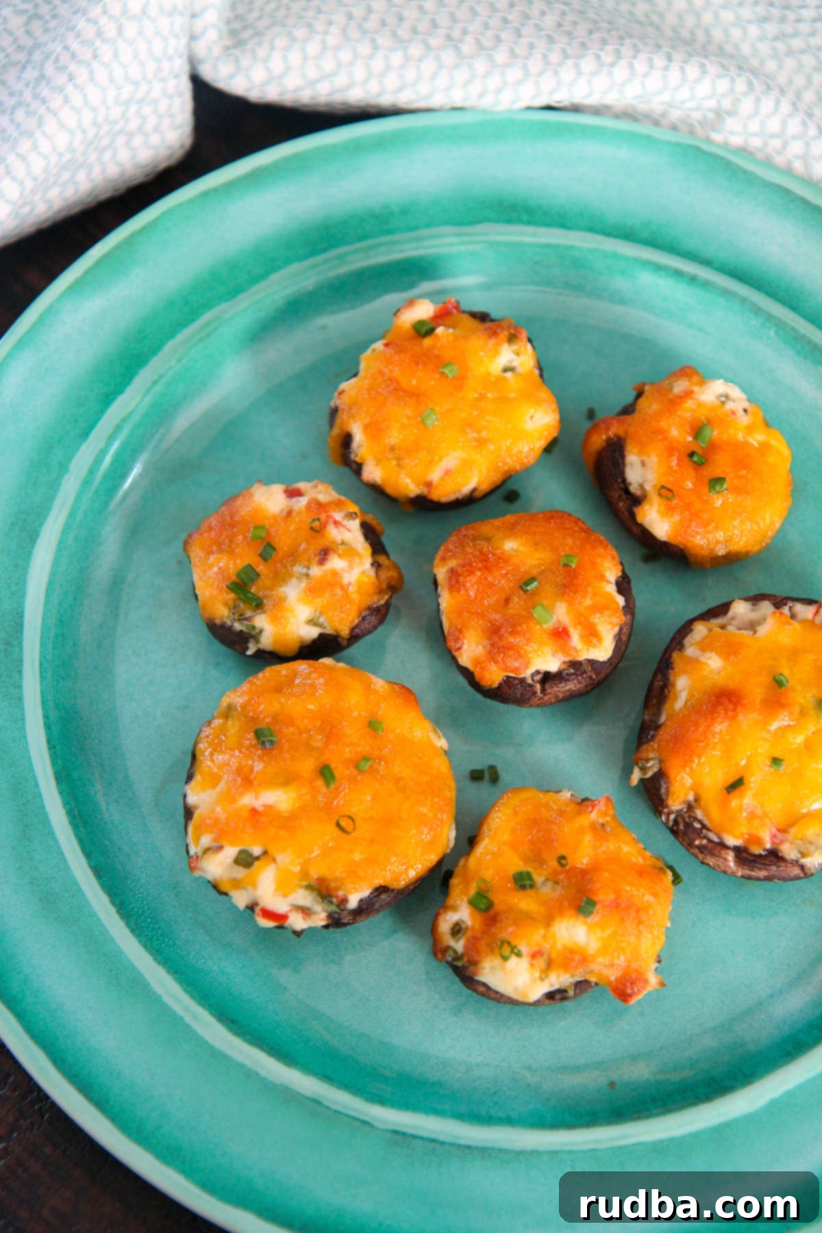 six cheese stuffed mushrooms on a blue plate 