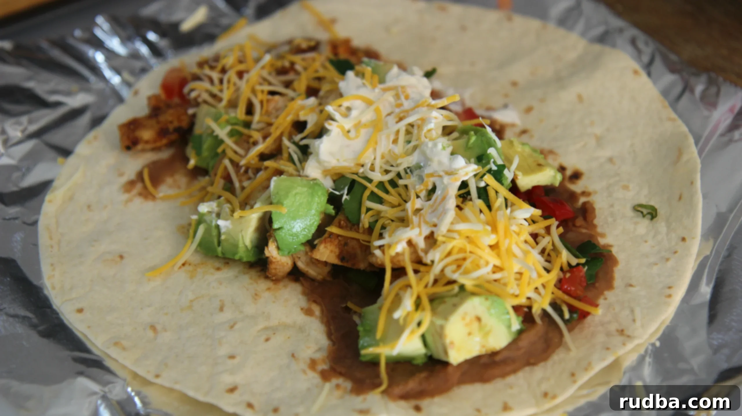Top this tex-mex burrito with cheese and sour cream. 