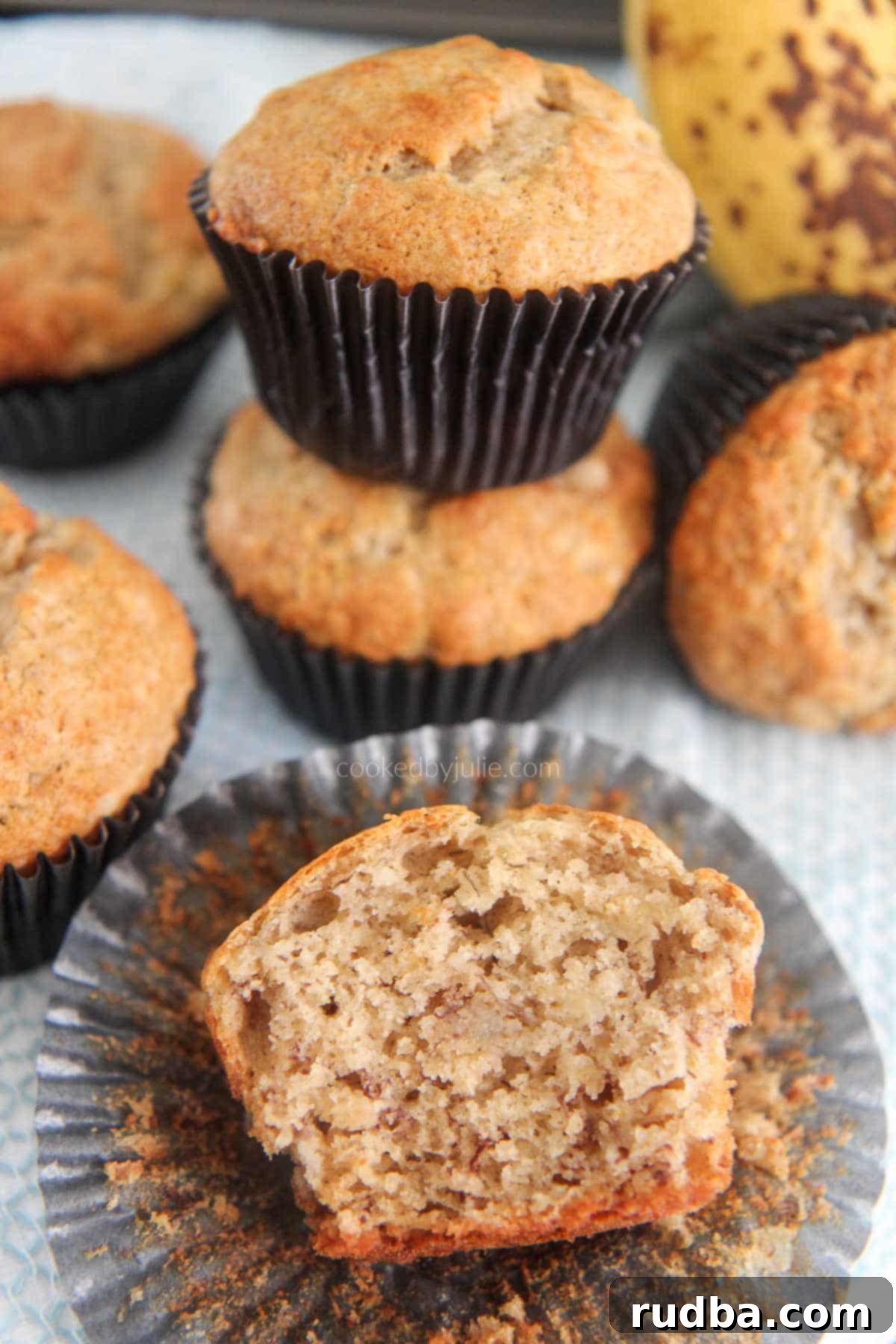 A perfectly baked banana muffin, split open to reveal its moist, fluffy interior.