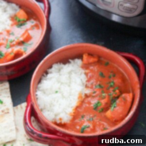The Ultimate Instant Pot Butter Chicken 5 Two small bowls with creamy Instant Pot Butter Chicken and pita bread on the side.