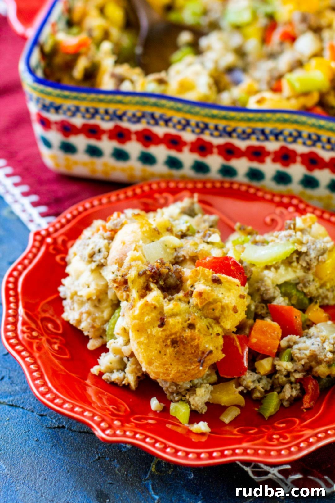 stuffing on a red plate with a casserole dish in the background