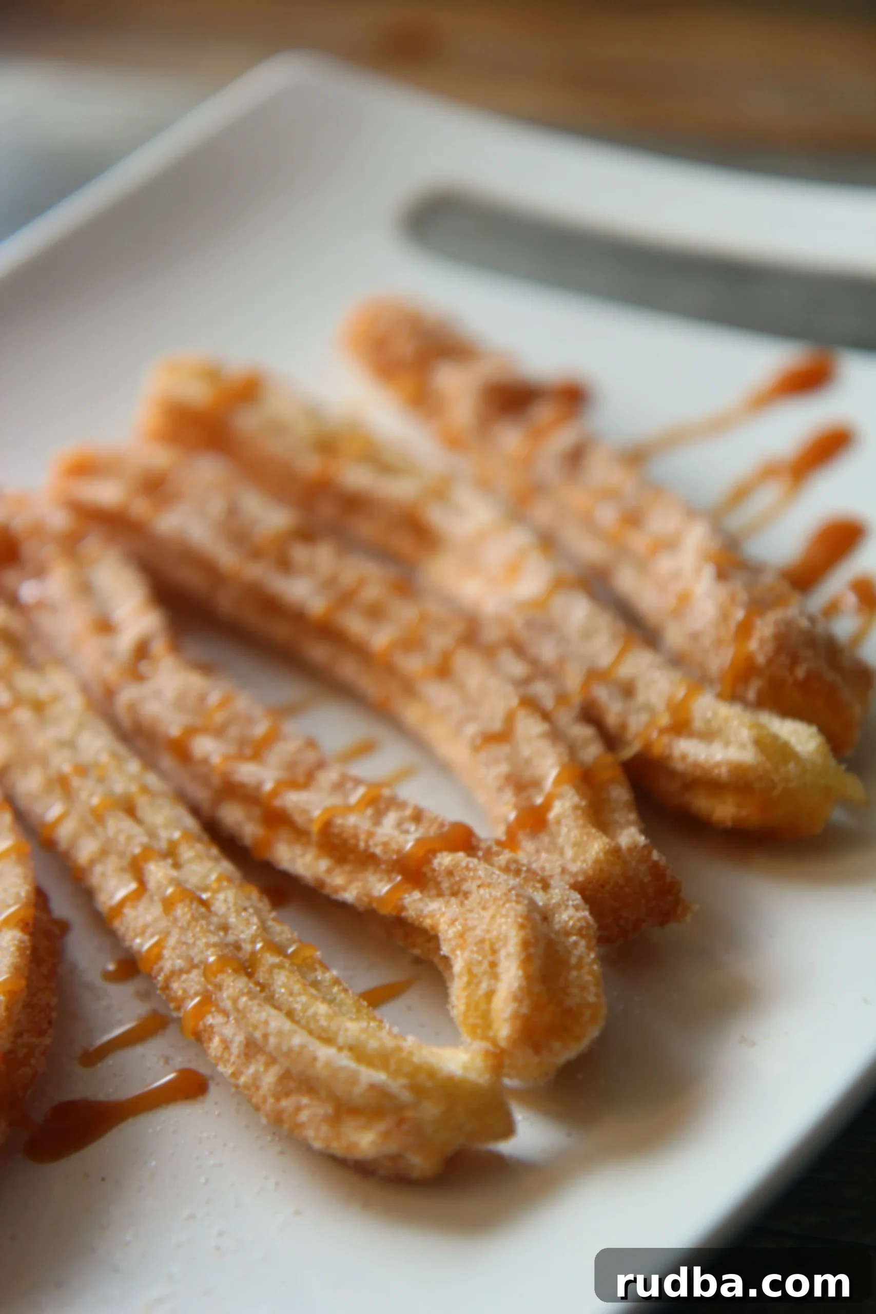 five churros on a white plate.