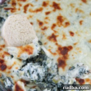 Creamy Spinach Artichoke Delight 8 spinach and artichoke dip in a glass bowl with bread