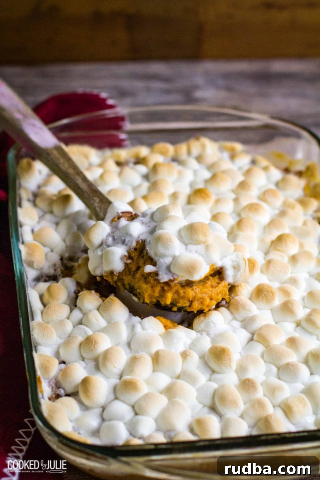 sweet potato casserole in a baking dish with wooden spoon