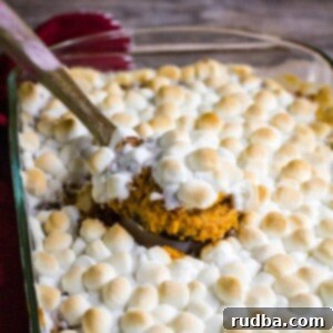 sweet potato casserole in a baking dish with wooden spoon