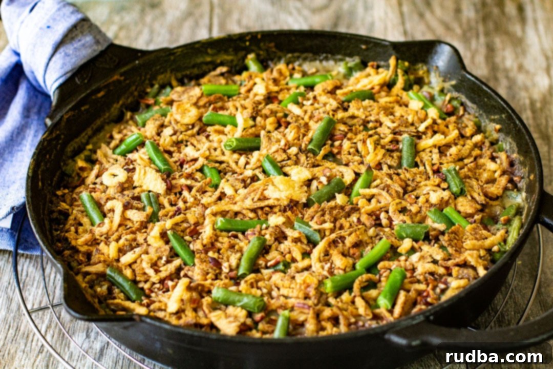 Golden brown green bean casserole with crispy French fried onions fresh out of the oven in a black skillet