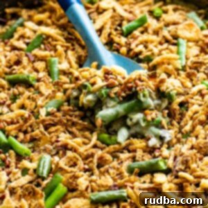 A spoonful of creamy green bean casserole with crispy fried onions, ready to be enjoyed