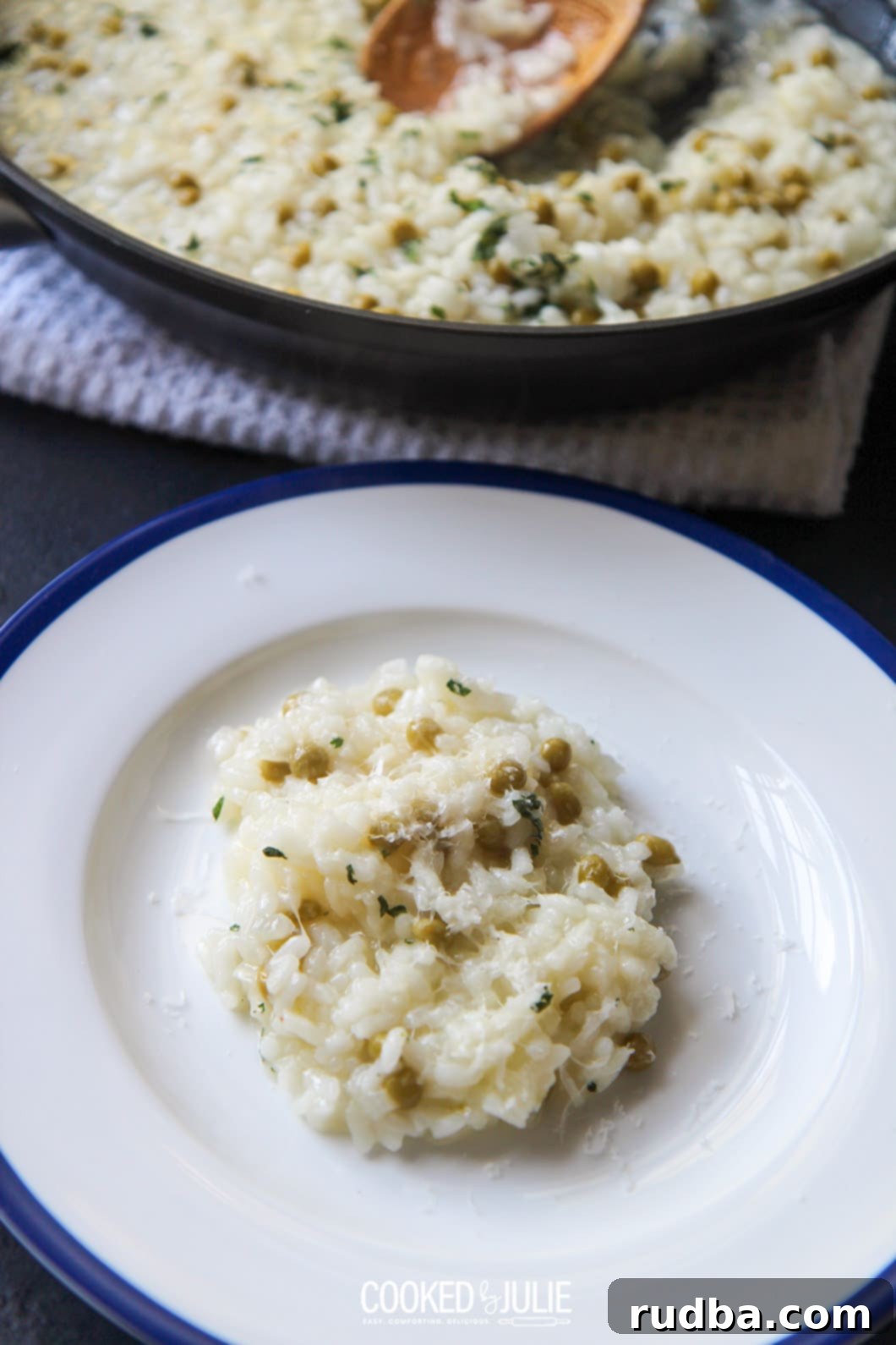 A small bowl of cooked Arborio rice with a cooking skillet in the background, showing creamy risotto texture