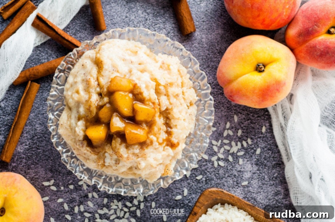 Peachy Rice Dream 5 Creamy baked rice pudding served in a clear glass bowl, accented with cinnamon sticks and a side of fresh peaches, showcasing its appealing texture.