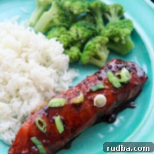 Dynamite Baked Salmon 6 salmon with scallions and rice and broccoli on a blue plate