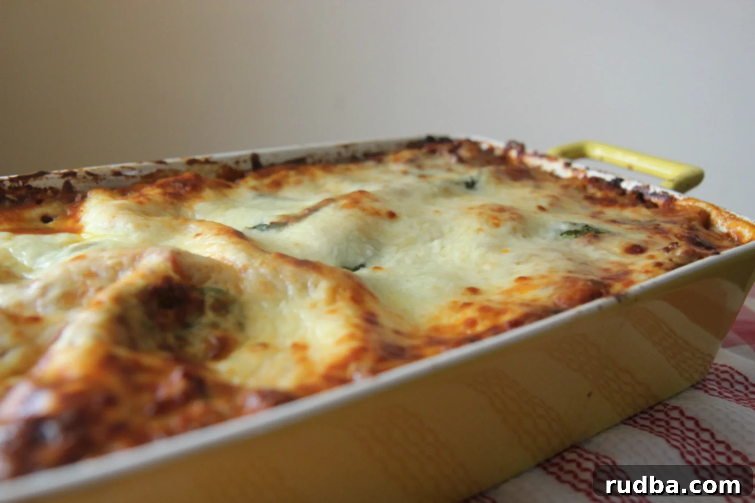 Close-up of the Ultimate Lasagna, showcasing its rich, golden-brown top and bubbling cheese in a casserole dish.