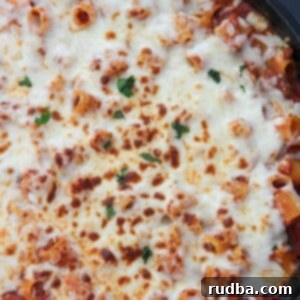 Baked Rigatoni 5 rigatoni with sauce and cheese in a black skillet