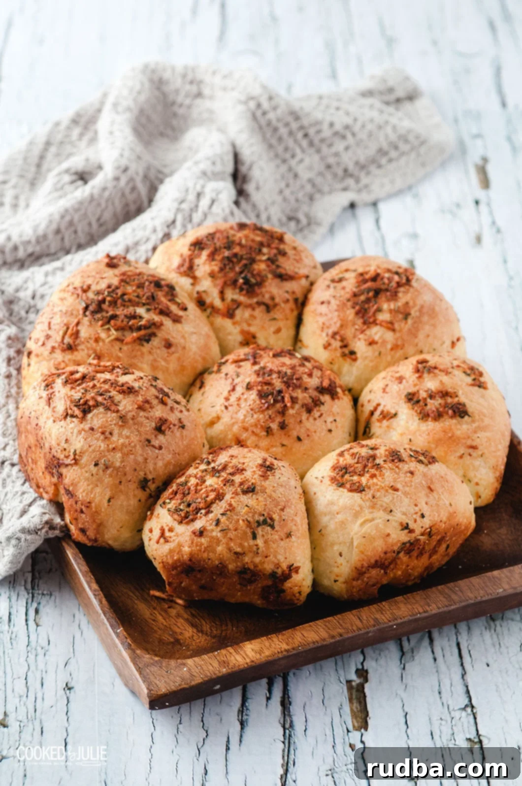 eight dinner rolls on a wooden board