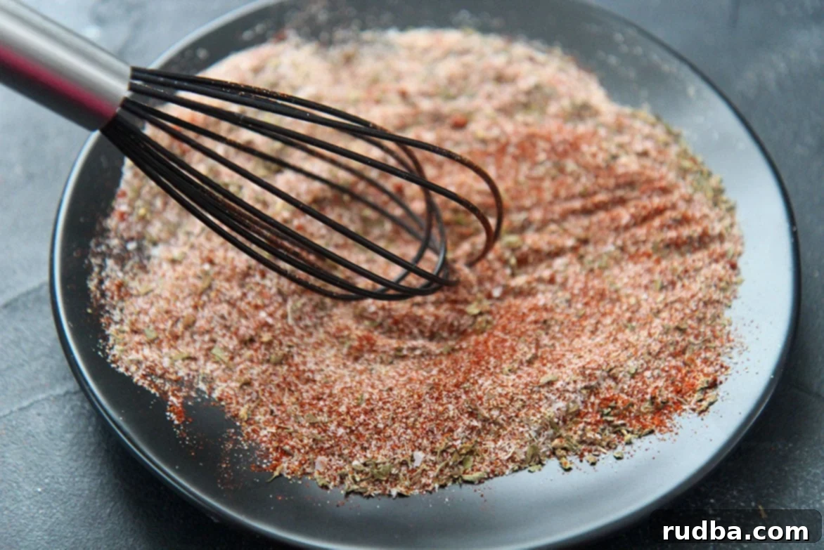 Combined spices on a black plate, showing the rich color of the Cajun blend