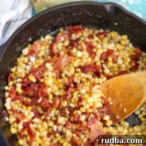 Southern Fried Corn with Crispy Bacon 4 corn and bacon in a cast iron skillet with a wooden spoon