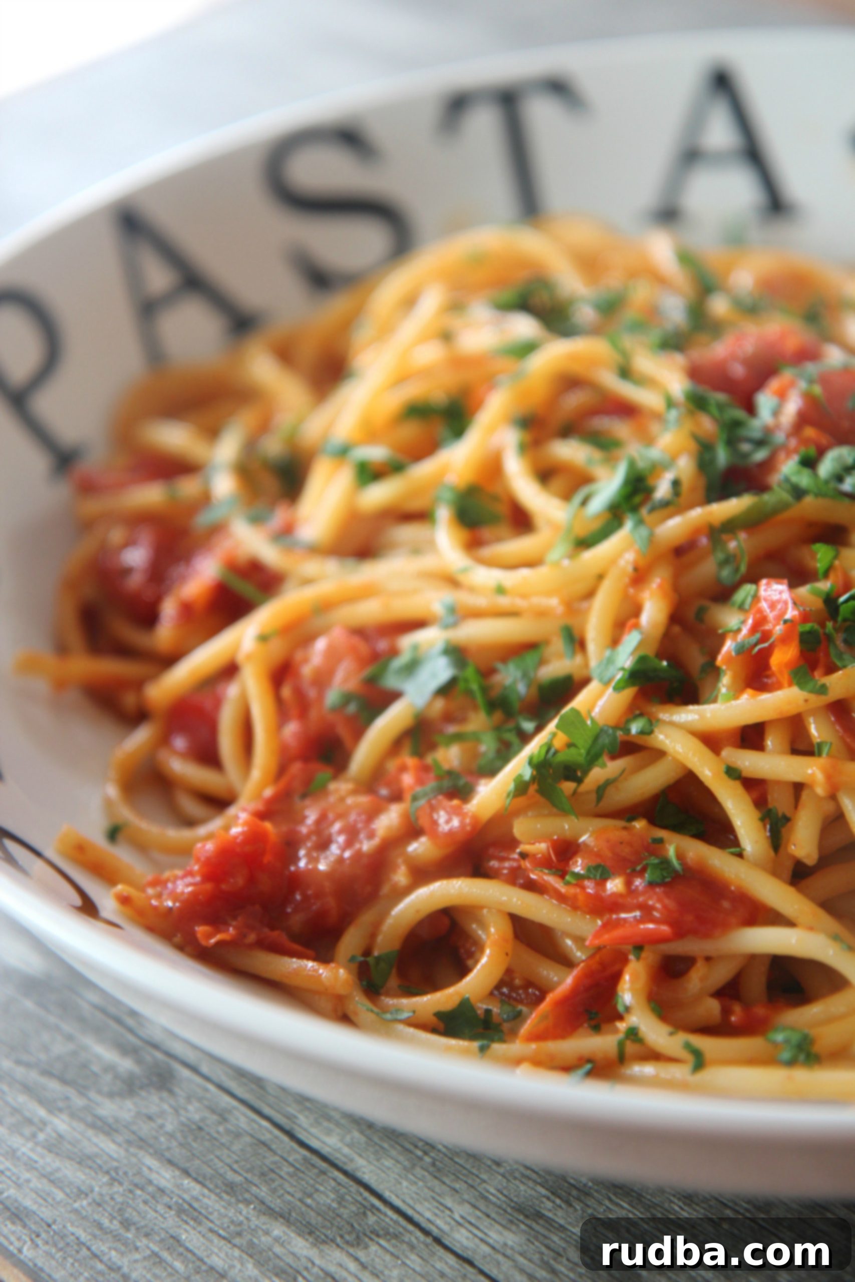 Tender angel hair pasta coated in freshly roasted grape tomatoes and topped with parmesan cheese and vibrant fresh herbs