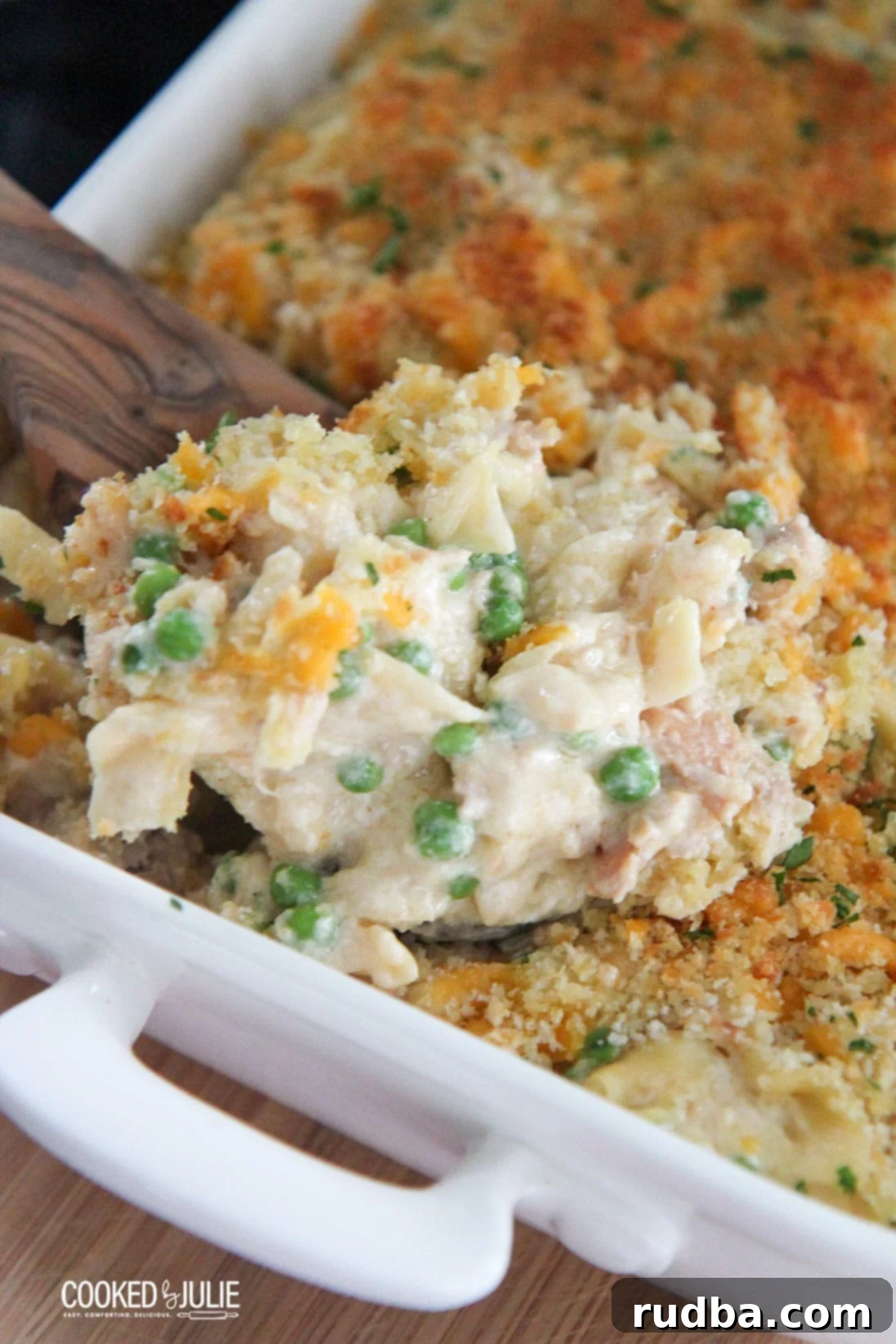 Classic tuna noodle casserole in a white baking dish with a wooden spoon, ready to be served