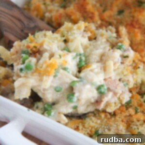 Creamy Tuna Noodle Bake 8 tuna noodles in a white baking dish with a wooden spoon