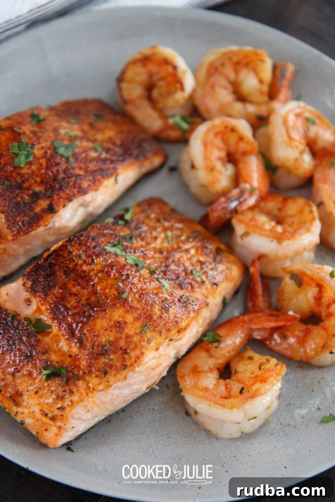 Cajun salmon and shrimp on a gray plate with creamy sauce