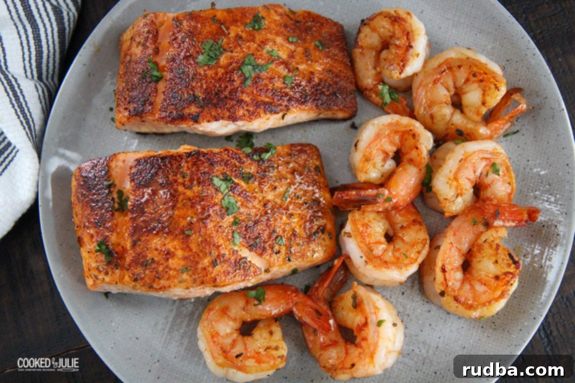 2 salmon fillets and 8 shrimp on a plate with fresh herbs