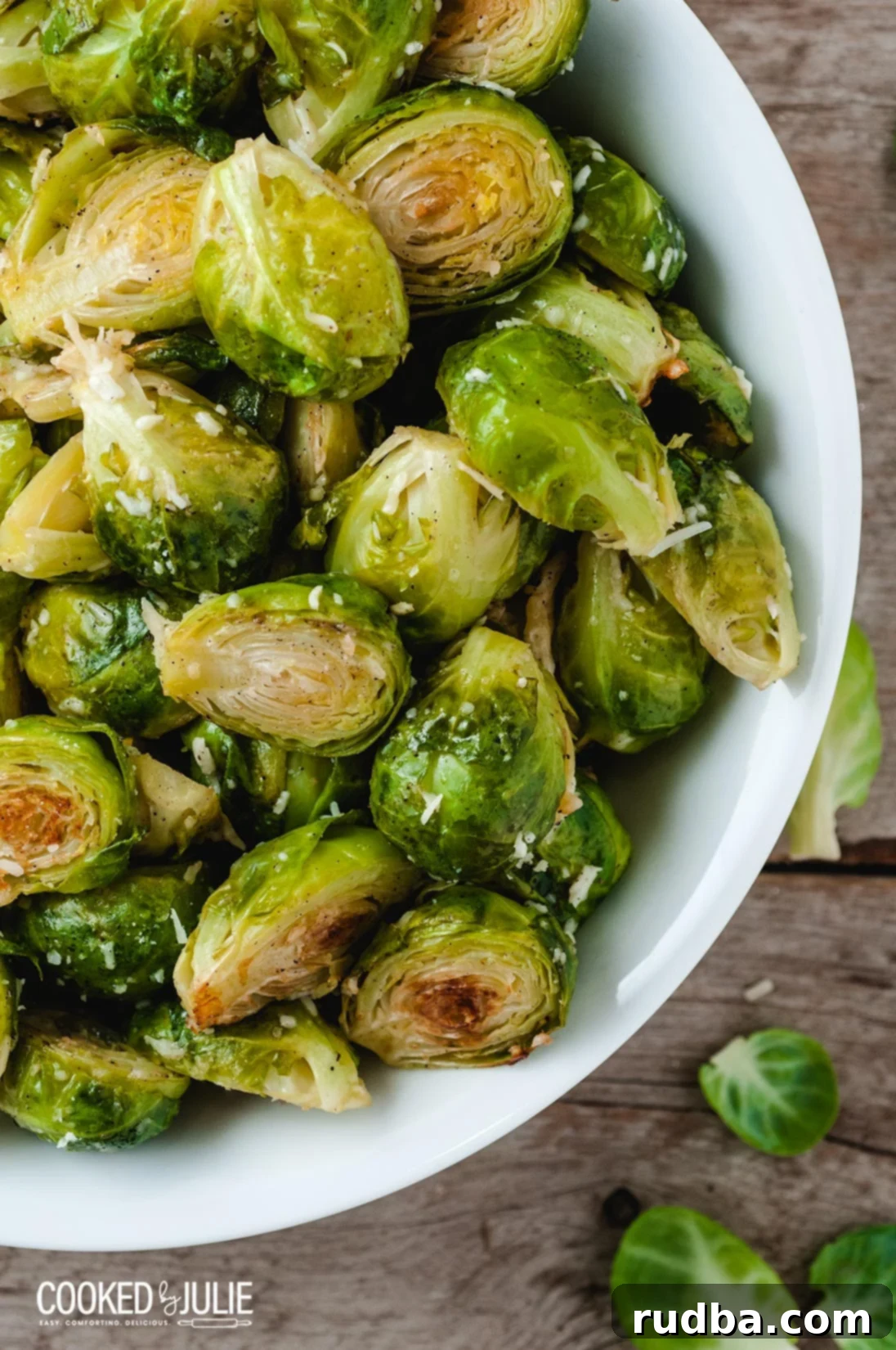 A serving of baked Brussels sprouts with parmesan cheese in a rustic white bowl