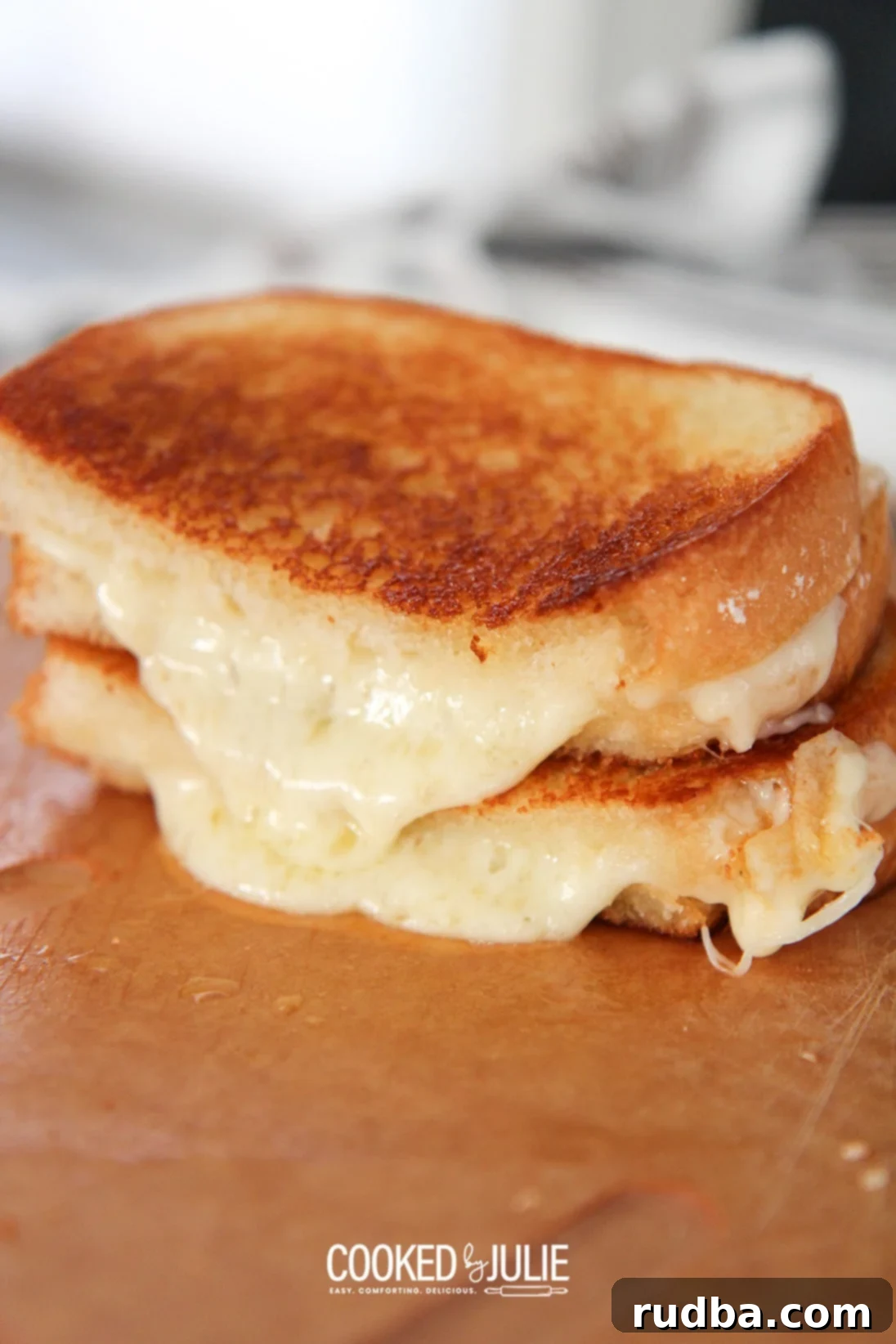 two grilled cheese sandwiches on a wooden board, golden brown and perfectly melted