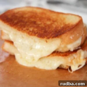 two grilled cheese sandwiches on a wooden board