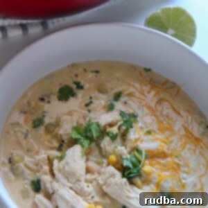 Dreamy Creamy White Chicken Chili 4 A beautifully presented bowl of creamy white chicken chili, garnished with a lime wedge and fresh cilantro.