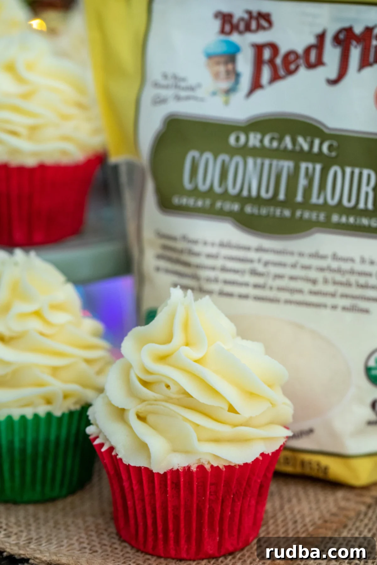 A single gluten-free gingerbread cupcake next to a bag of coconut flour, highlighting key ingredients.