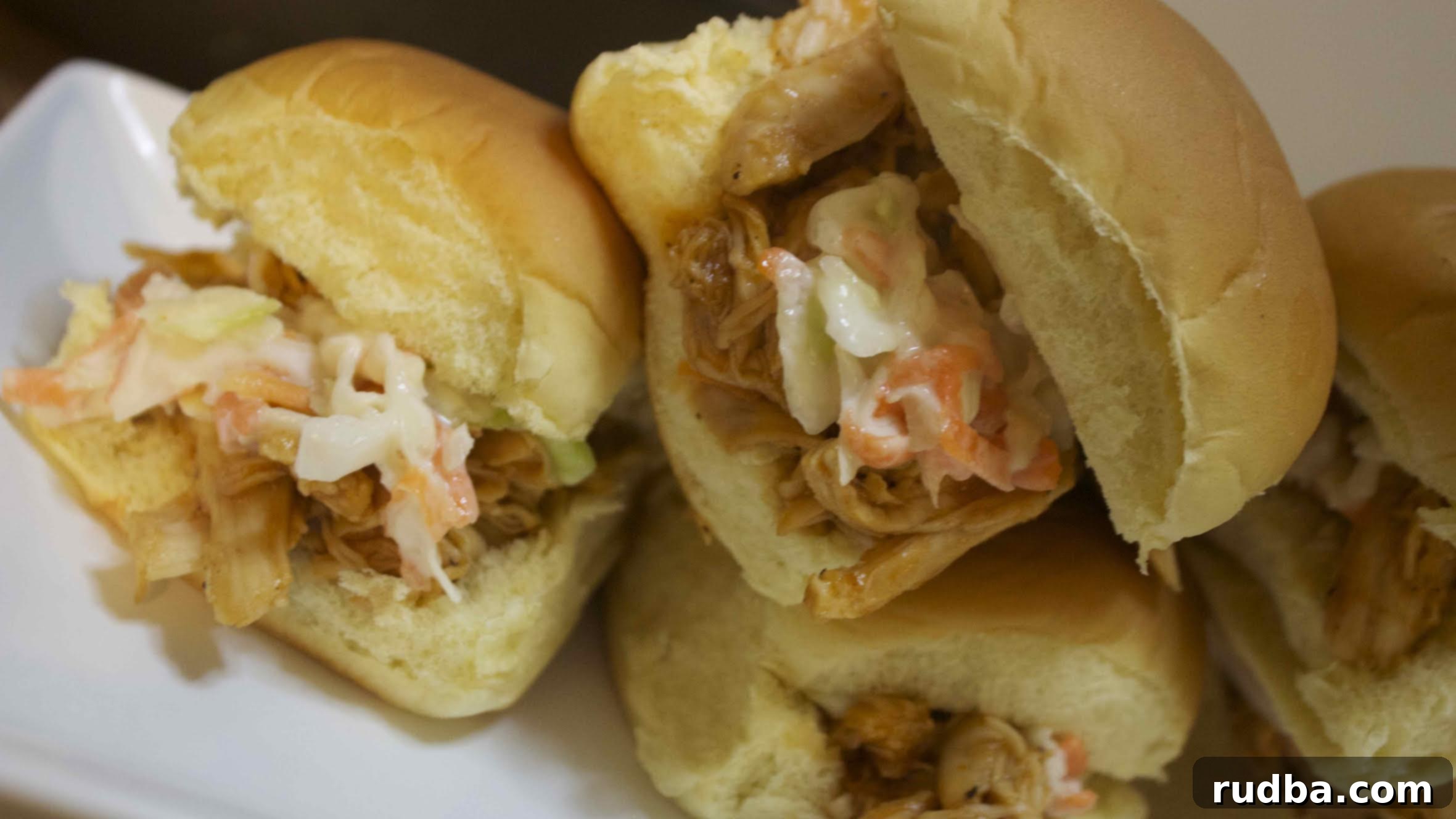 BBQ pulled chicken on soft dinner rolls topped with a sweet coleslaw 
