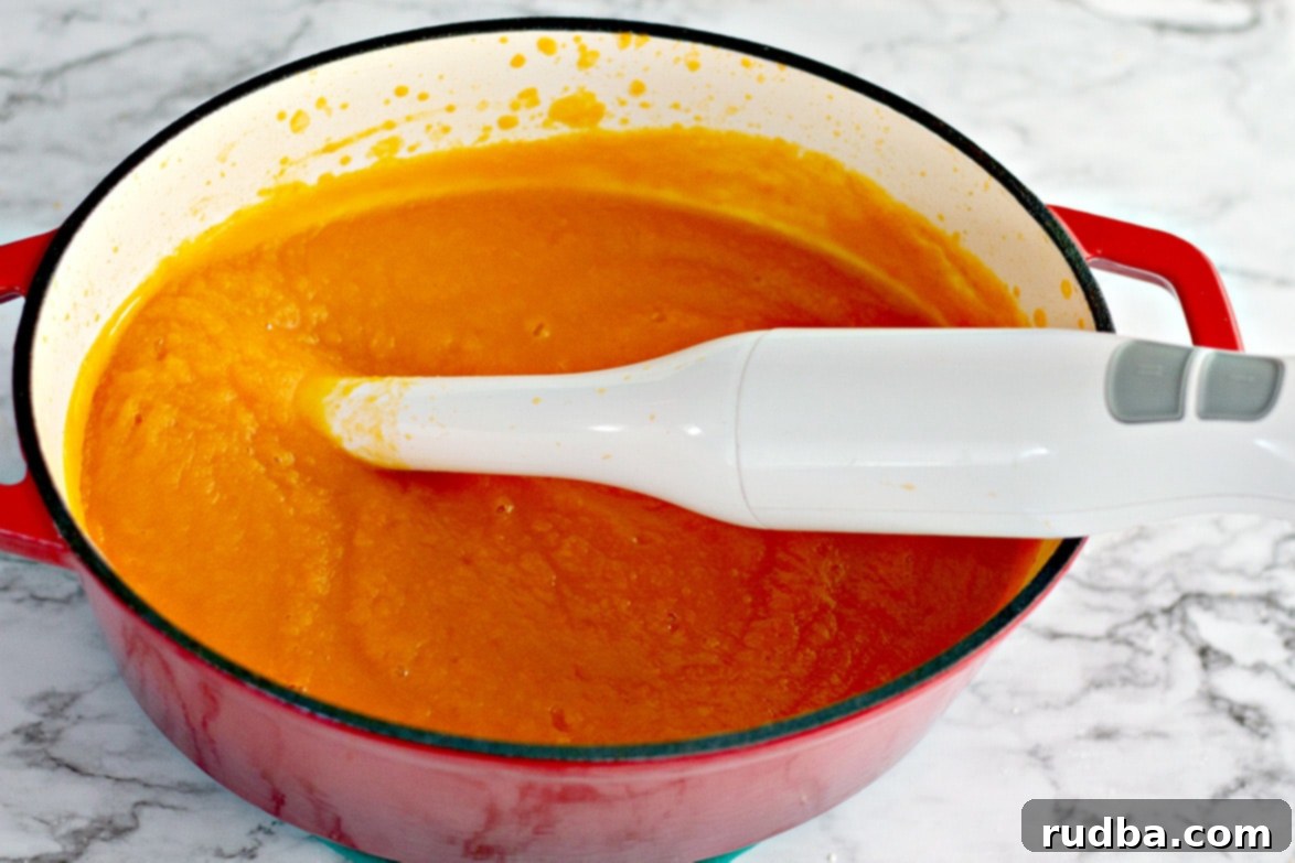 Creamy Roasted Butternut Squash Soup 4 Smooth, pureed roasted butternut squash soup in a Dutch oven, with an immersion blender resting inside