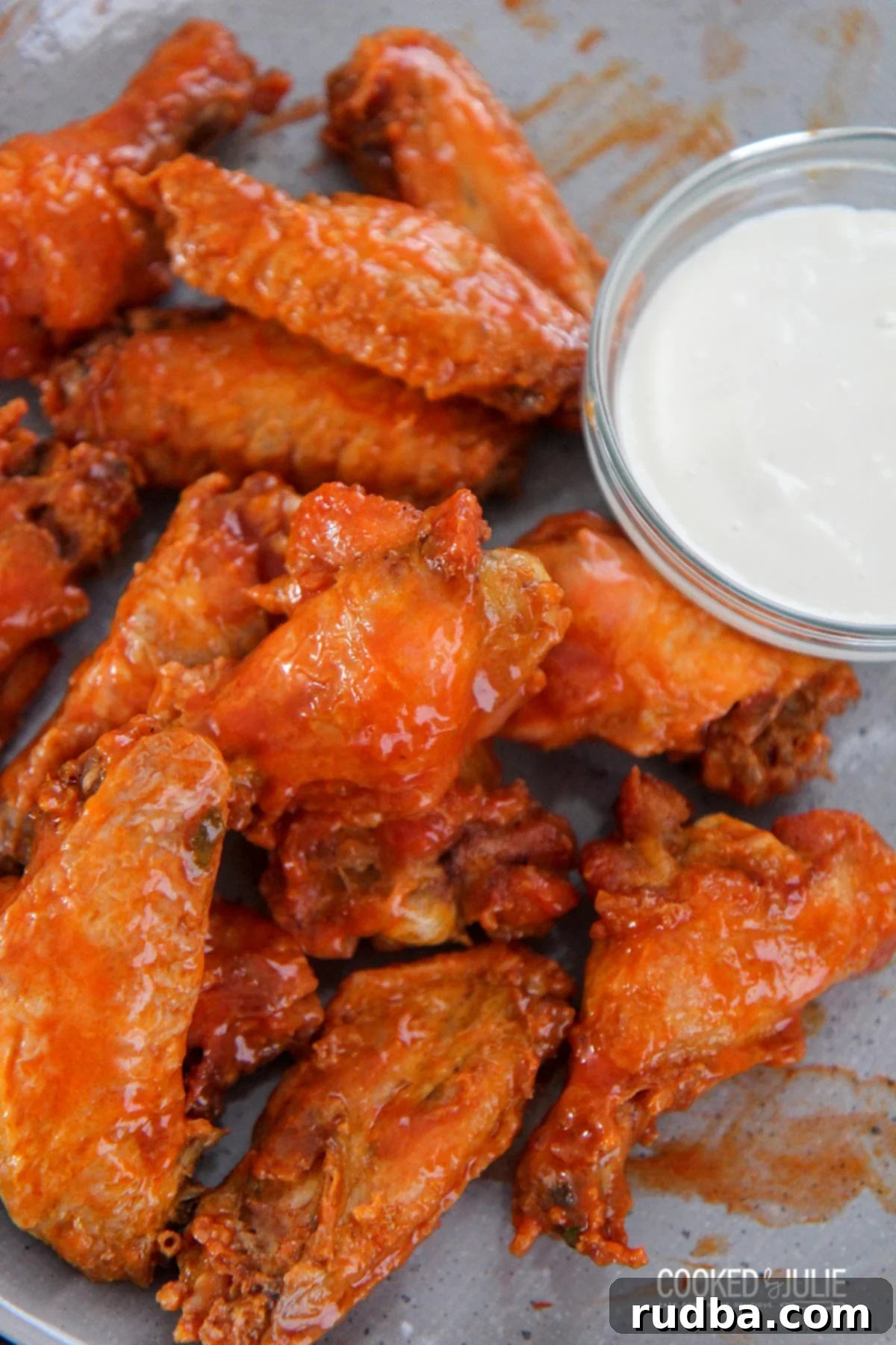 crispy baked buffalo wings on a gray plate with a side of bleu cheese dressing and celery sticks