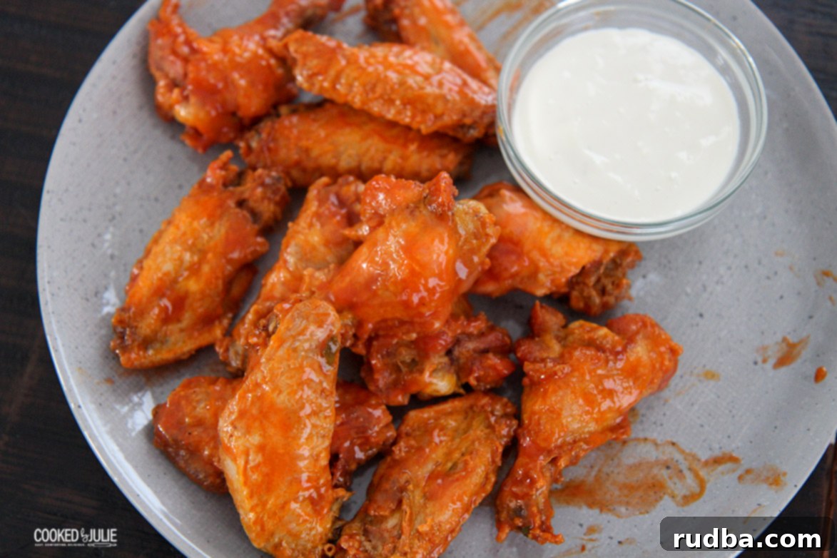 chicken wings on a gray plate with dip on the side 