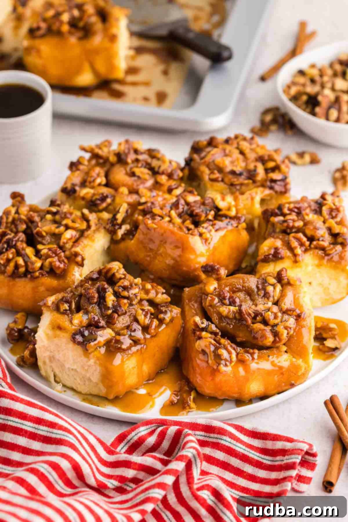 A delightful sticky bun placed on a white plate, served alongside a comforting cup of coffee, ready for a delicious breakfast or snack.