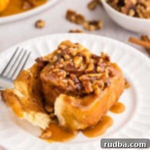 One sticky bun on a white plate with a fork.