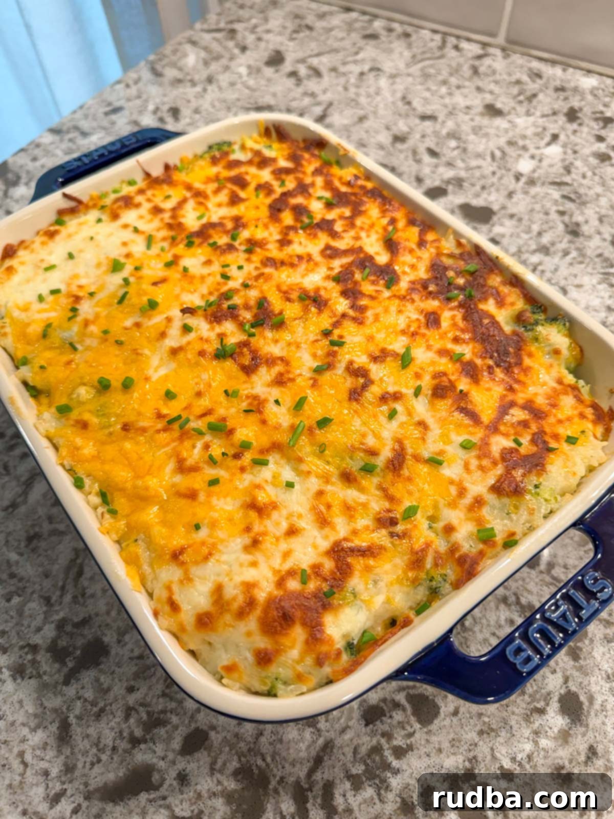 Cheesy Broccoli Rice Bake 2 Cheesy broccoli rice casserole in a blue baking dish, ready to be served.