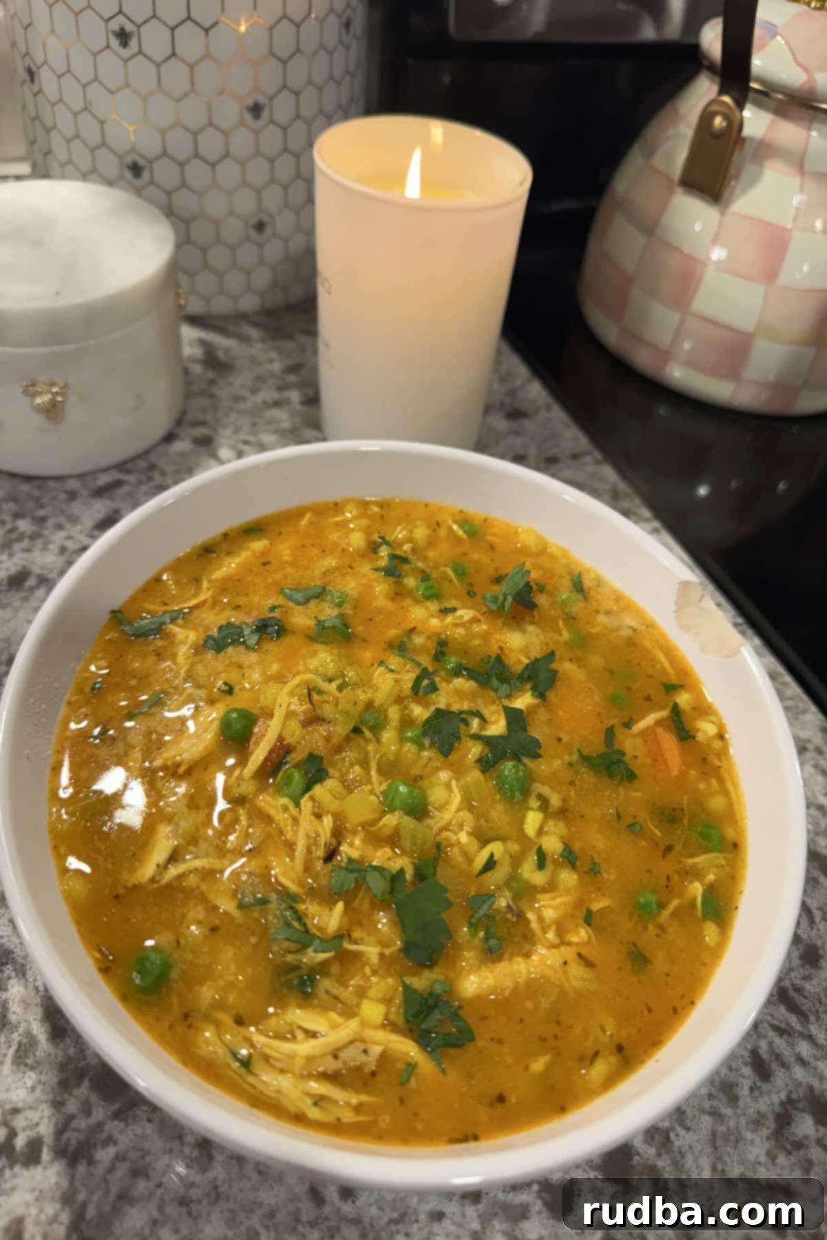 A steaming bowl of chicken barley soup, showcasing the tender chicken, plump barley, and colorful vegetables in a clear broth.