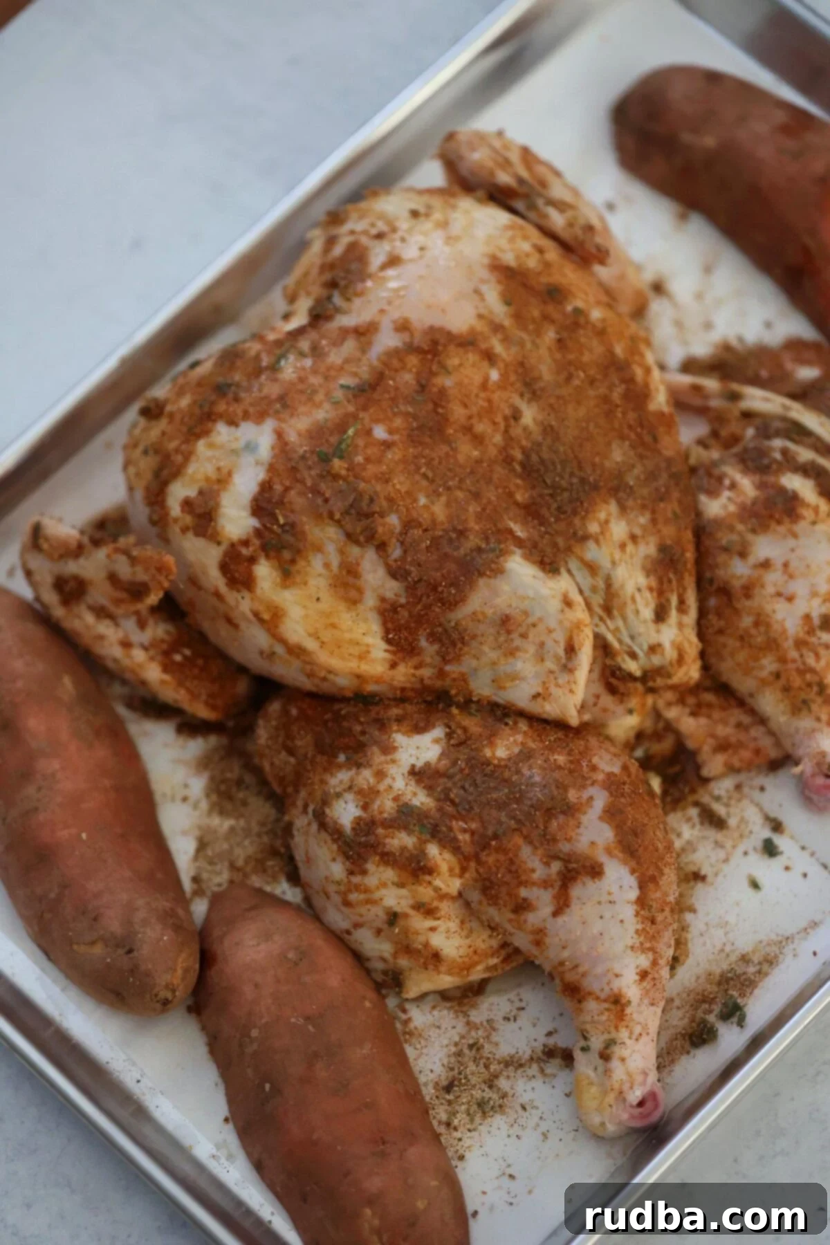 Roasted Spatchcock Chicken and Root Vegetables 4 raw seasoned chicken and uncooked sweet potatoes.
