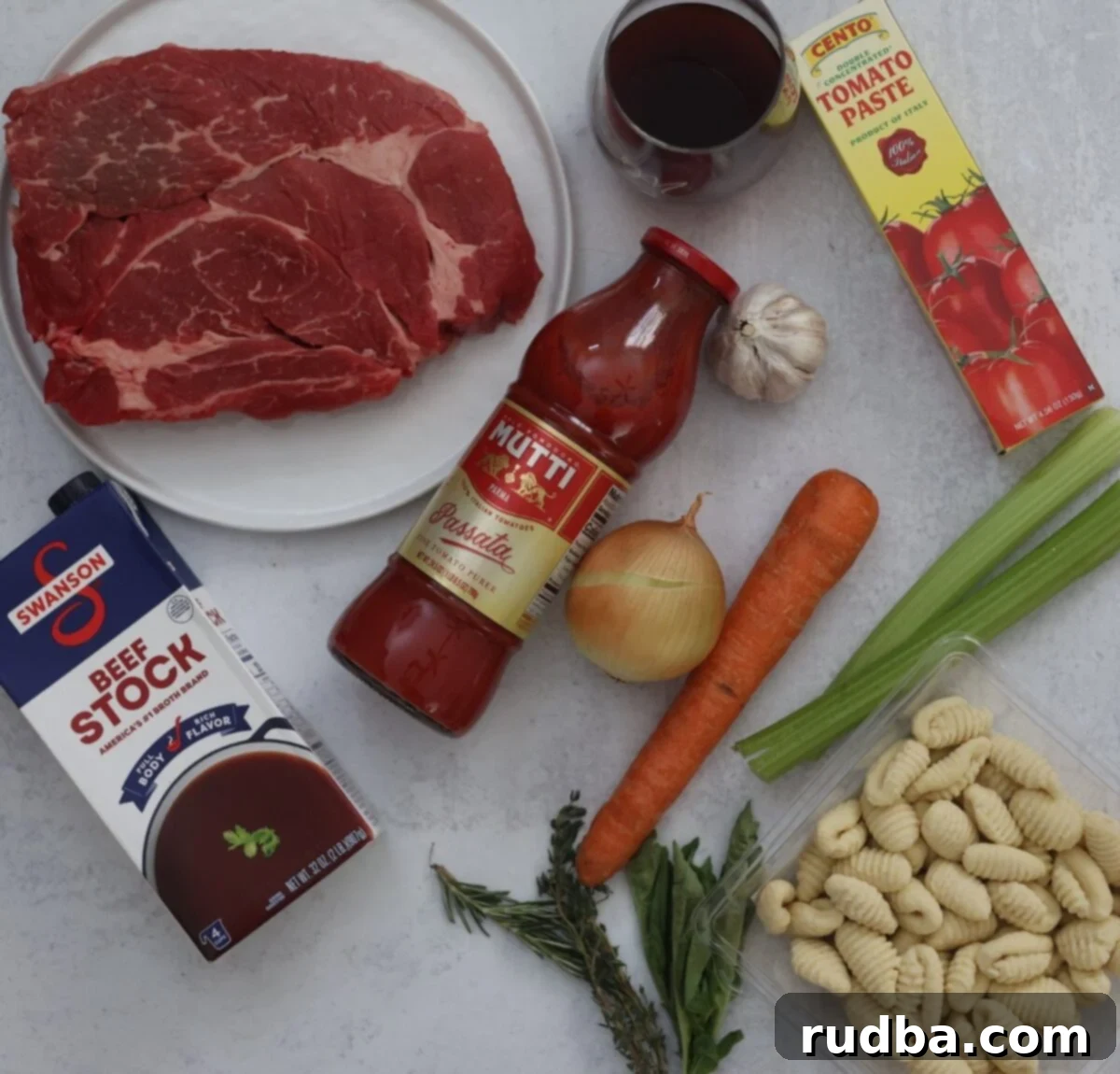 Braised beef gnocchi ingredients: chuck roast, tomato sauce, stock, wine, veggies, herbs, and gnocchi.